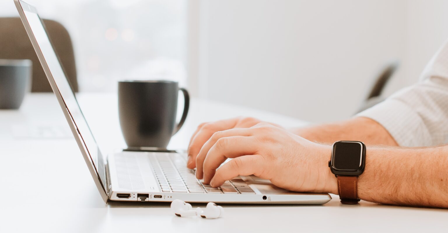 Recruiter typing on a laptop to find job candidates